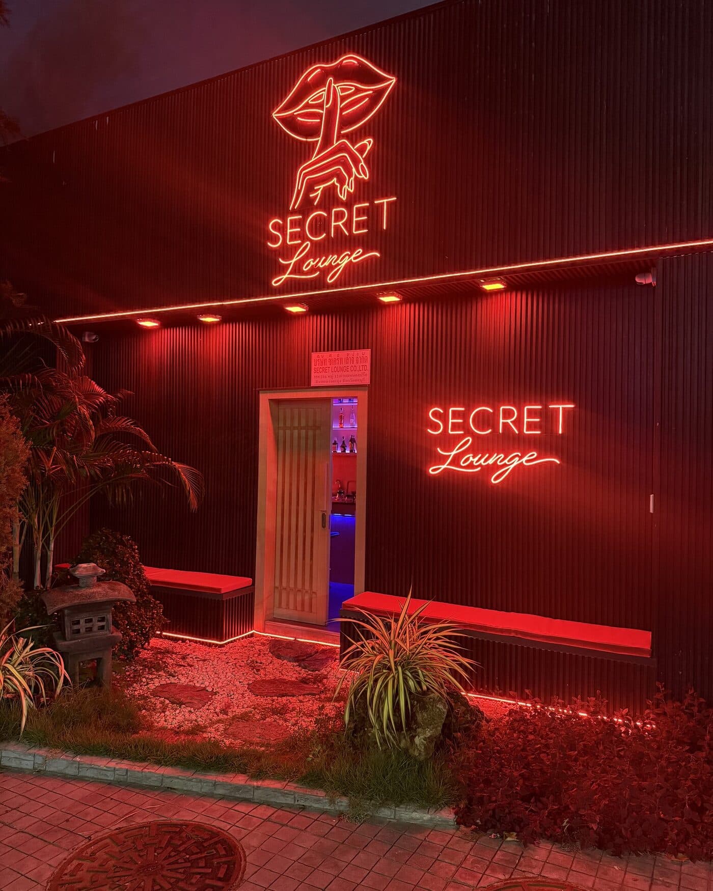 Secret Lounge at night — red neon lips logo on the black slatted facade, Pratumnak Soi 5, Pattaya